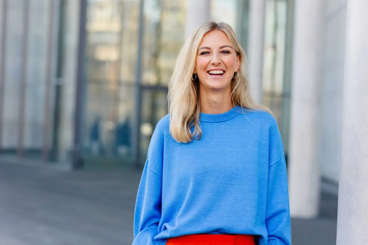 Fröhliches Personal Branding Portrait einer Autorin im blauen Pullover – fotografiert von Barbara Meyer-Selinger, in München an der Pinakothek der moderne