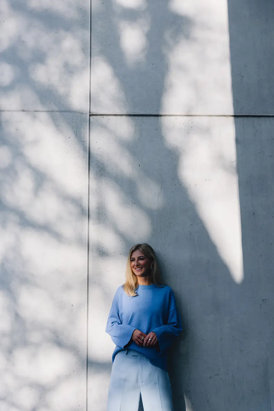 Personal Branding Fotografie einer Unternehmerin vor Betonwand mit natürlichem Licht und Schatten